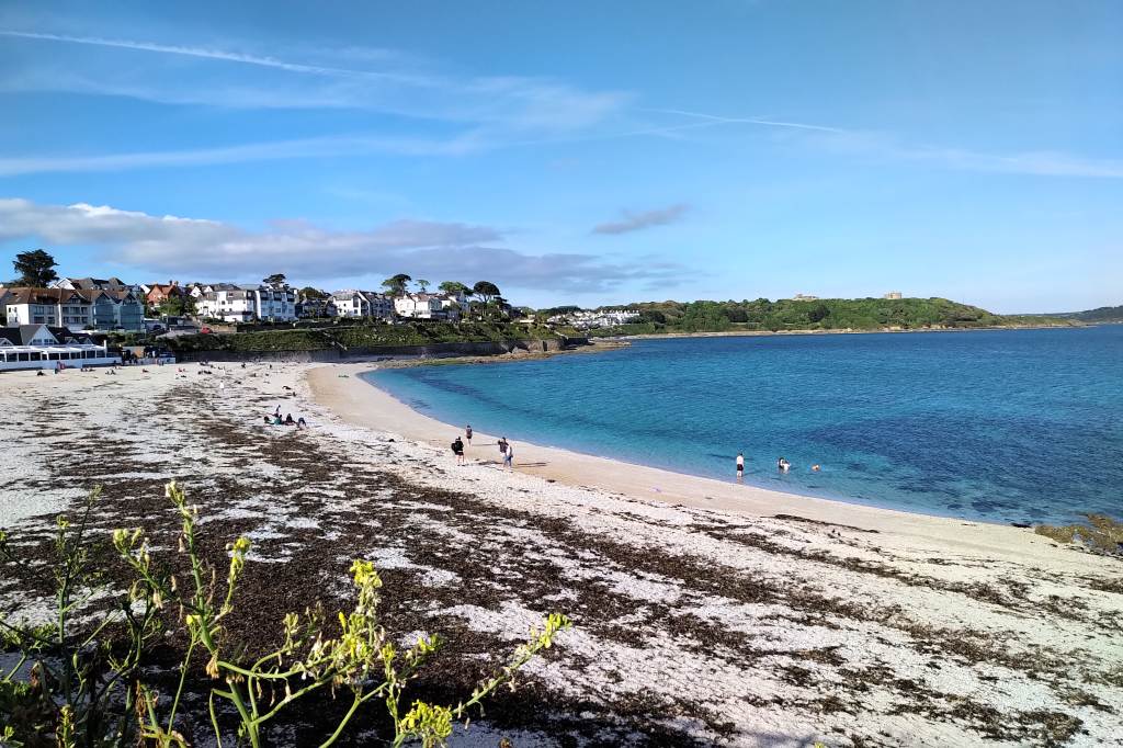Gyllyngvase Beach on 17 May 2020 on a sunny exercise excursion with a contrail in the sky